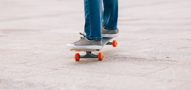 Skateboarder legs skateboarding at outdoors - Фото, изображение