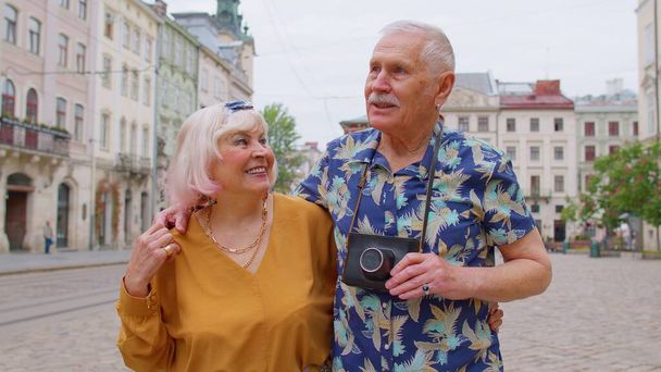 高齢のスタイリッシュな観光客男性、女性、祖母、夏の街で散歩をしている祖父の家族 - 写真・画像