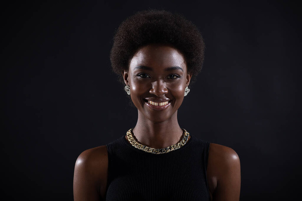Siyah stüdyo arka planında afro saç stili olan Afrikalı Amerikalı kadının yakın portresi. - Fotoğraf, Görsel