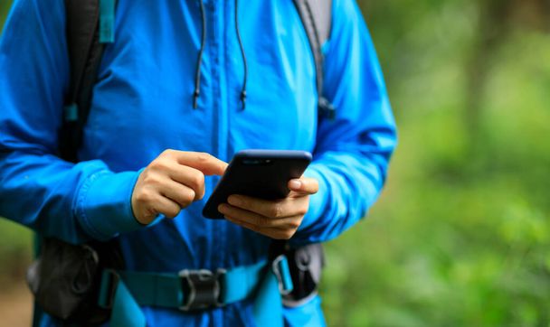 Woman hiker using smartphone  in spring forest - Foto, Imagem