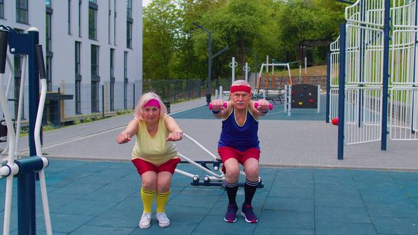 Idős férfi nő csinál aktív edzés nyújtás izmok guggoló fitness gyakorlat játszótéren - Fotó, kép