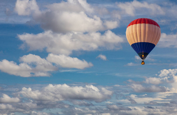 Luftaufnahme eines Heißluftballons, der in den blauen Himmel fliegt. Landschaftlich schöner bewölkter blauer Himmel. - Foto, Bild