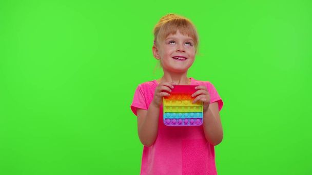 Müde gelangweilte Kinder Mädchen Kind Quetschpressen Anti-Stress-Touchscreen drücken Pop es beliebtes Spielzeug - Foto, Bild