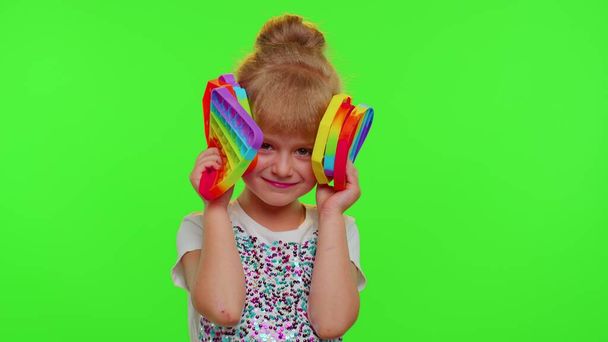 Gyermek lány gyerek gazdaság sok színes lapos szilikon buborékok érzékszervi játék, gyerek játszik pop it játék - Fotó, kép