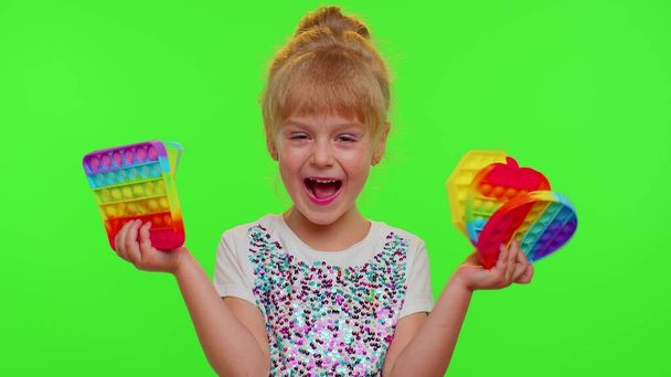 Enfants fille enfant tenant serrant écran tactile anti-stress pousser pop il jouet populaire sur la clé chromatique - Photo, image