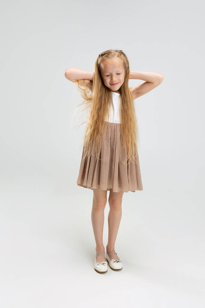 Beautiful little girl in modern stylish dress posing isolated on white studio background. Happy childhood concept. - Fotoğraf, Görsel