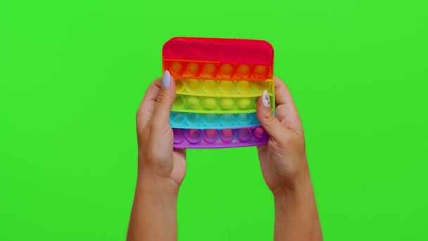 Nahaufnahme von Mädchen Hände spielen Quetschen Anti-Stress-Spielzeug einfache Grübchen Spiel isoliert auf Chroma-Schlüssel - Foto, Bild
