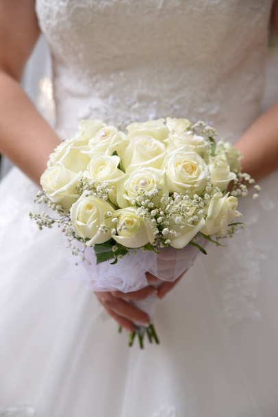 νύφη κρατώντας ένα μπουκέτο κίτρινα τριαντάφυλλα - Φωτογραφία, εικόνα