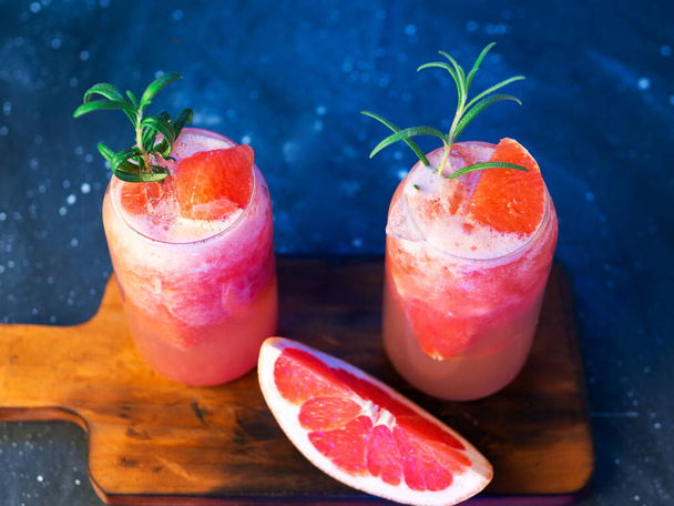 Дві склянки літнього освіжаючого лимонаду з грейпфрутом, подрібненим льодом, розмарином та содовою. Алкогольна версія з джином
 - Фото, зображення