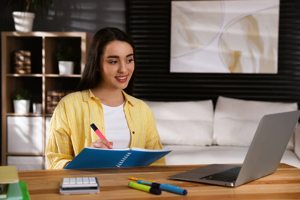 Young woman watching webinar at table in room - Photo, Image