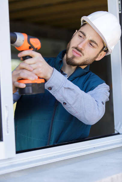 man is drilling a window frame - Fotoğraf, Görsel