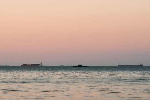 Submarine not far from wooden pier in the sea. Military exercise - Foto, afbeelding