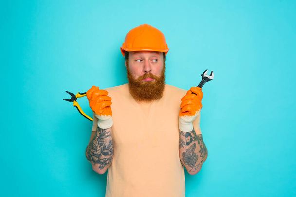 Werknemer met gele hoed is in de war over zijn werk - Foto, afbeelding