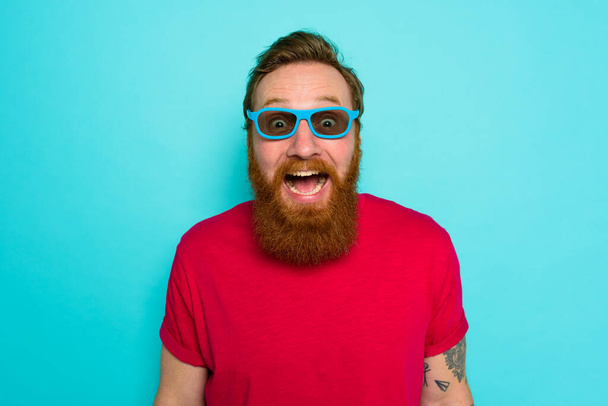 Mann mit Bart und Sonnenbrille ist verwundert und glücklich - Foto, Bild