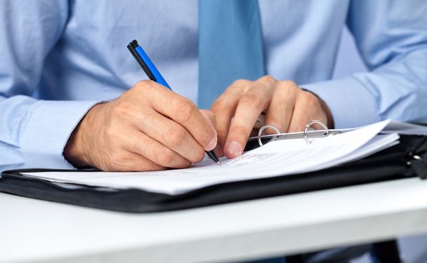 Close up of businessman signing a contract. - Foto, afbeelding