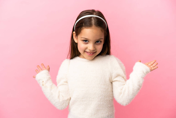 Little caucasian girl isolated on pink background with shocked facial expression - Foto, Imagem