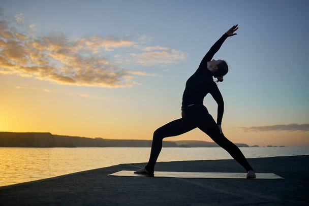 postawa kobiecej jogi w sylwetce o zachodzie słońca - Zdjęcie, obraz