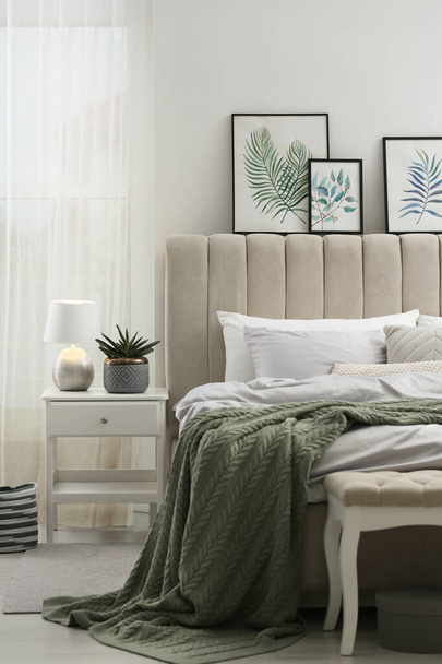 Bett mit stilvoller grauer Bettwäsche in der Nähe der weißen Wand im Zimmer - Foto, Bild