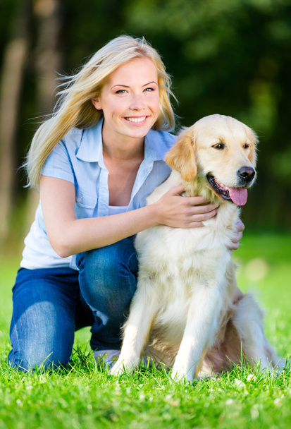 Woman with dog sitting on the grass - Foto, Bild