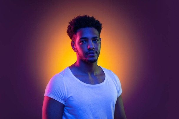 Retrato de um jovem africano no estúdio. Modelo masculino de alta moda em luzes de néon brilhantes coloridas. Conceito de design de arte. - Foto, Imagem