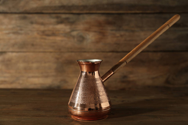 Beautiful copper turkish coffee pot on wooden table - Foto, Imagem