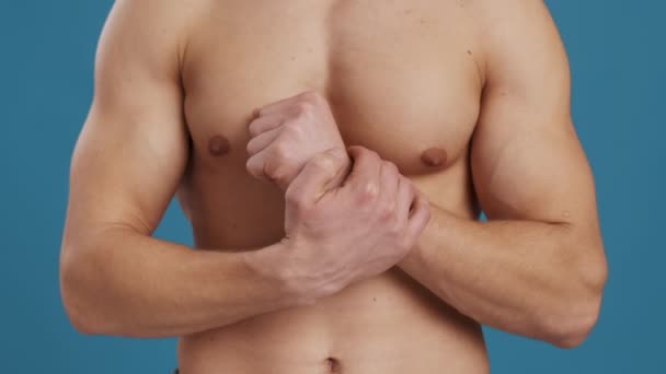 Rannekanavaoireyhtymä. Tuntematon lihaksikas mies hieromassa tulehtuneita ranteitaan, kärsien käsien särystä - Materiaali, video