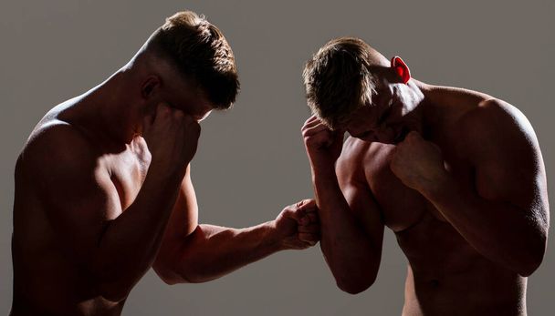 Dwóch bokserów boksuje na odizolowanym tle. Dwóch mężczyzn ćwiczących tajski boks w sylwetce, MMA. Dwa profesjonalne bokserki. Dwóch młodych bokserów przeciwko sobie w pojedynku - Zdjęcie, obraz