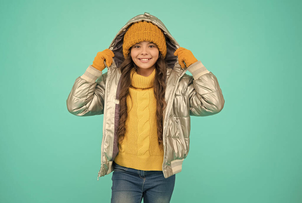 happy child feel comfortable and warm in padded jacket and knitted clothing in winter weather, cold winter - Фото, изображение