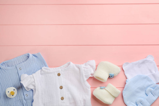 Flat lay composition with baby clothes and accessories on pink wooden background, space for text - Foto, Imagen