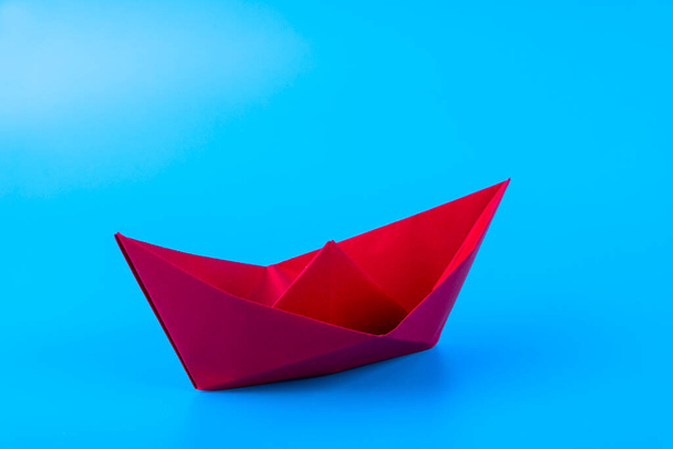 red paper ship in new direction on blue background, New normal concept, copy space - Fotó, kép