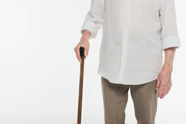 részleges kilátás idős férfi alkalmi ruhák gazdaság sétapálca elszigetelt fehér - Fotó, kép