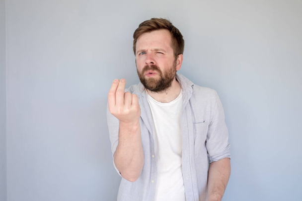 Bearded Caucasian man in a shirt argues, he is trying to prove something to someone, looks with bewilderment and shows a hand gesture.  - Photo, Image