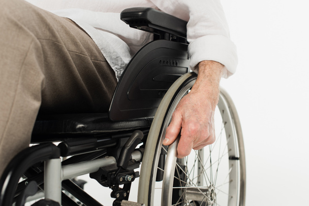 vista parziale di anziano seduto in sedia a rotelle isolato su bianco - Foto, immagini