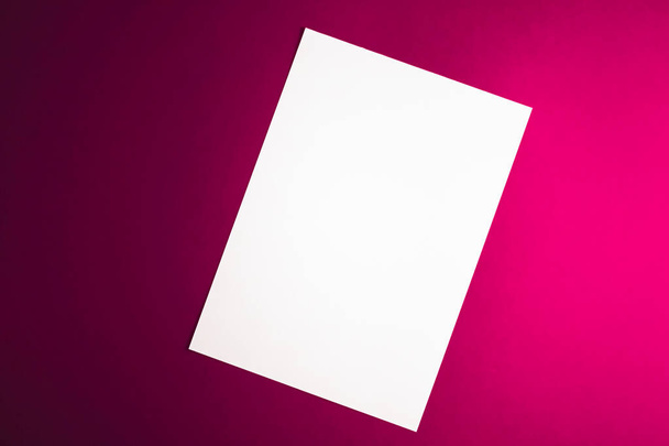 Carta A4 bianca, bianca su sfondo rosa come lastra di cancelleria per ufficio, lastra piatta di lusso e design dell'identità del marchio per mockup - Foto, immagini