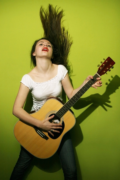 νεαρή γυναίκα με πάθος παίζει κιθάρα - Φωτογραφία, εικόνα