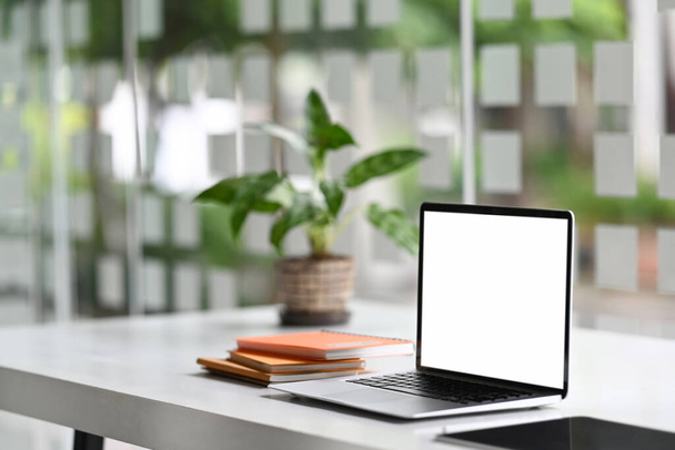 Mesa de trabalho e laptop com fontes de tela em branco no escritório moderno. - Foto, Imagem