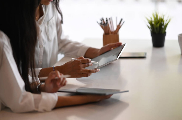 Przycięte wizerunek businesswoman pracuje razem na laptopie w nowoczesnym biurze. - Zdjęcie, obraz