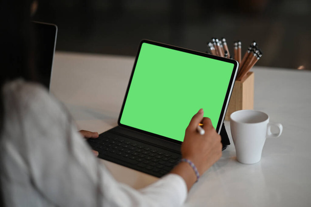 ノートパソコン付きデジタルタブレット画面上のスタイラスペンの書き込みを使用してビジネス女性,現代オフィスの机の上のノートブック. - 写真・画像