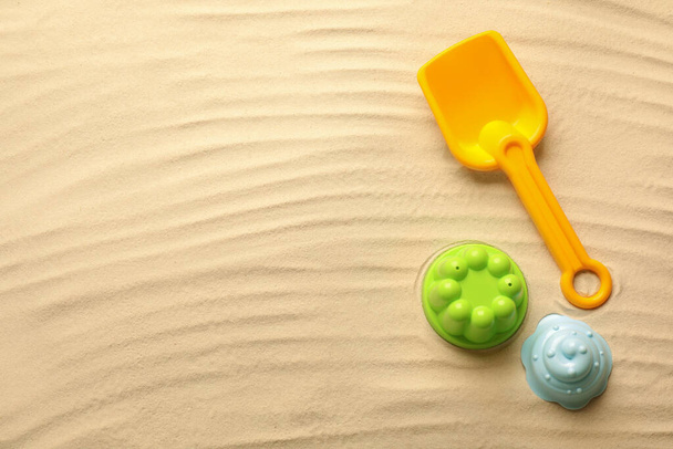 Flat lay of beach toy kit on sand, space for text. Outdoor play - Photo, image