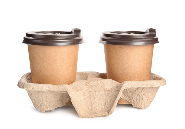 Takeaway paper coffee cups in cardboard holder on white background - Foto, afbeelding