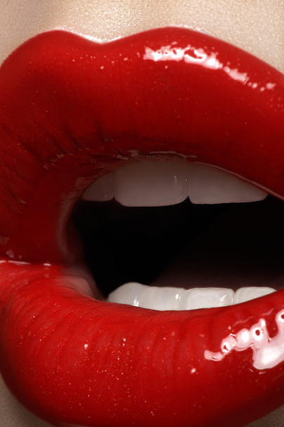Close-up de lábios de mulher com maquiagem brilhante moda vermelho brilhante. Maquiagem de batom macro sangrento
 - Foto, Imagem