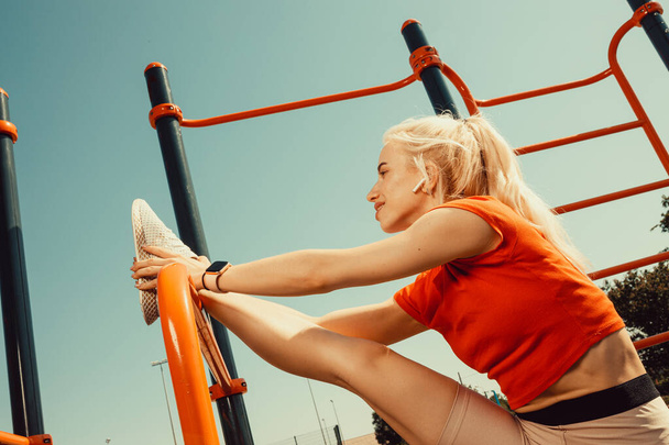 beautiful blonde doing stretching on the playground - Photo, Image