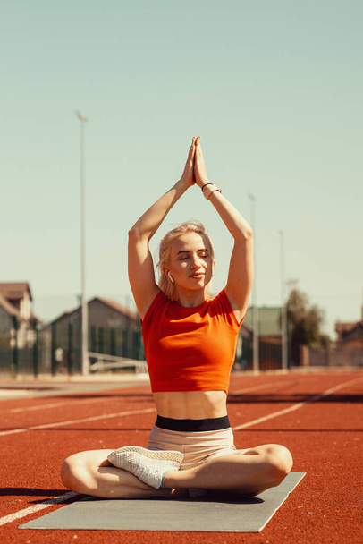 young blonde relaxes on a sports mat - Фото, зображення