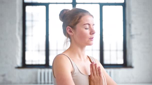 Femme calme fait des exercices de respiration tenant la main dans namaste - Séquence, vidéo