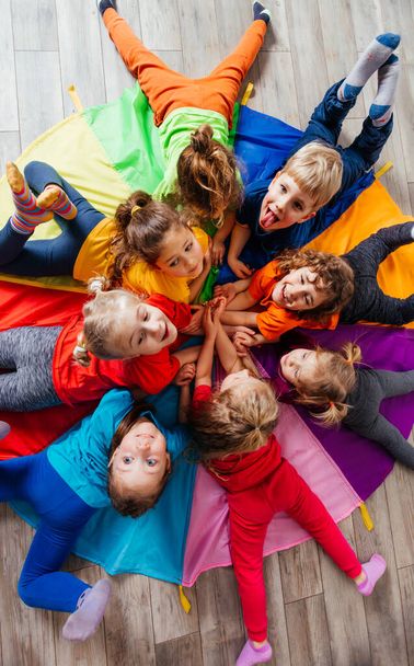 Cheerful children playing team building games on a floor - Фото, изображение
