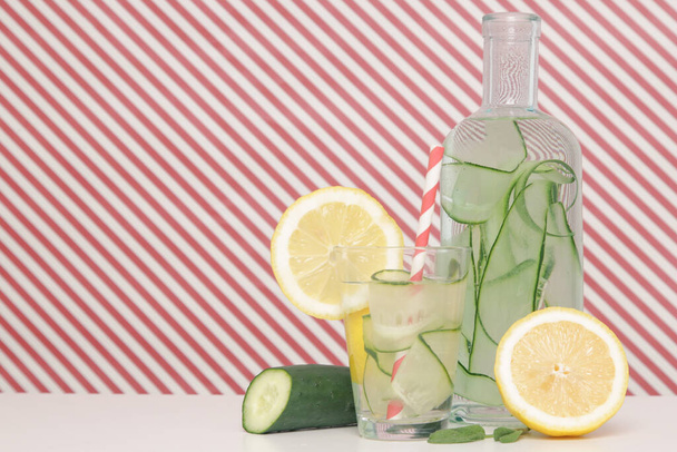 Lemon cucumber water with colorful paper straw. Healthy detox drink. - Photo, Image