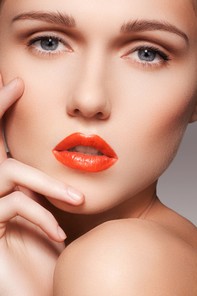 Portrait of beautiful woman's purity face with bright red lips make-up. Cute model with clean shiny skin - 写真・画像