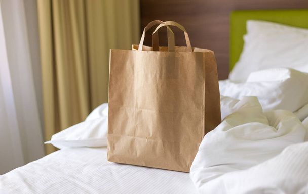 Παράδοση τροφίμων τσάντα σκάφος στο κρεβάτι την ηλιόλουστη μέρα. Παράδοση με οποιοδήποτε καιρό όλο το εικοσιτετράωρο στον πελάτη. Οικολογική συσκευασία γρήγορου φαγητού με μεγάλο πρωινό - Φωτογραφία, εικόνα