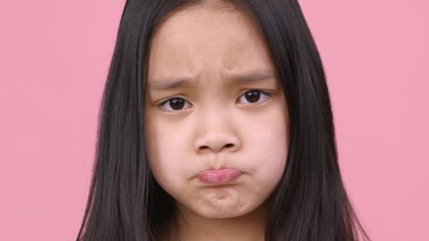 Caprichos de niños. De cerca retrato de chica asiática haciendo pucheros labios, sintiéndose molesto y ofendido, no consiguió lo que quería - Metraje, vídeo