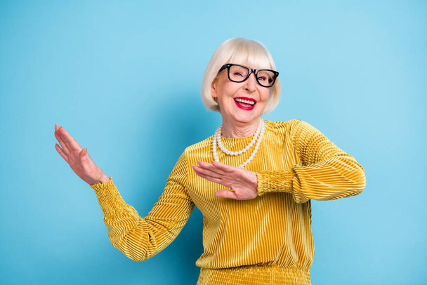 Photo de cheveux courts funky senior lady vêtements de danse lunettes de chemisier isolé sur fond de couleur bleue - Photo, image